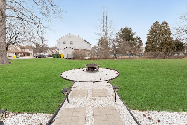 view of yard with an outdoor fire pit and fence