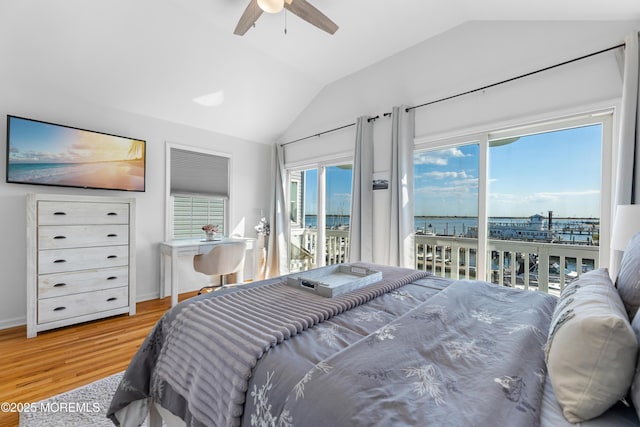 bedroom with vaulted ceiling, a water view, ceiling fan, hardwood / wood-style flooring, and access to outside