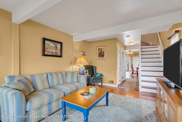 living room featuring light hardwood / wood-style floors and beam ceiling