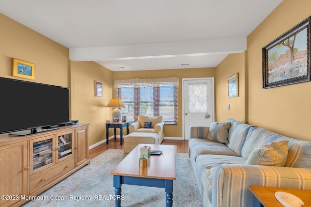 living room with light wood-type flooring and beamed ceiling