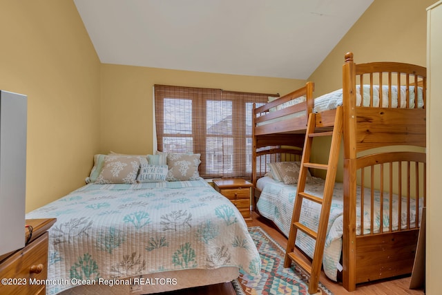 bedroom featuring light hardwood / wood-style floors and vaulted ceiling