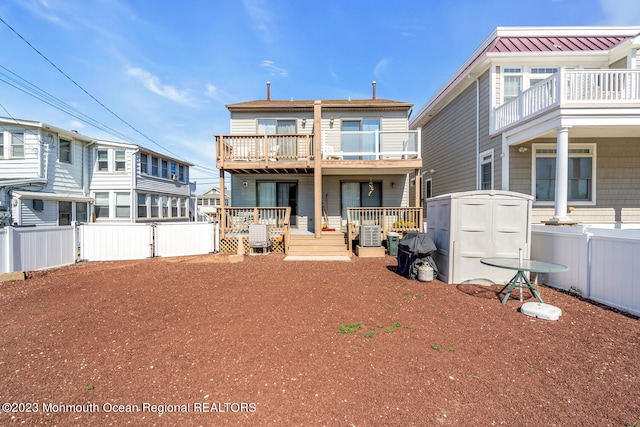 back of house featuring a deck and a storage shed