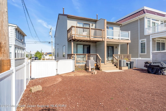 rear view of property featuring a balcony and central AC