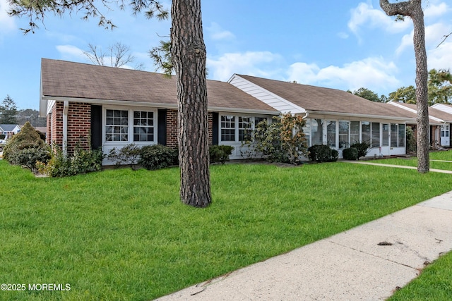 single story home featuring a front lawn