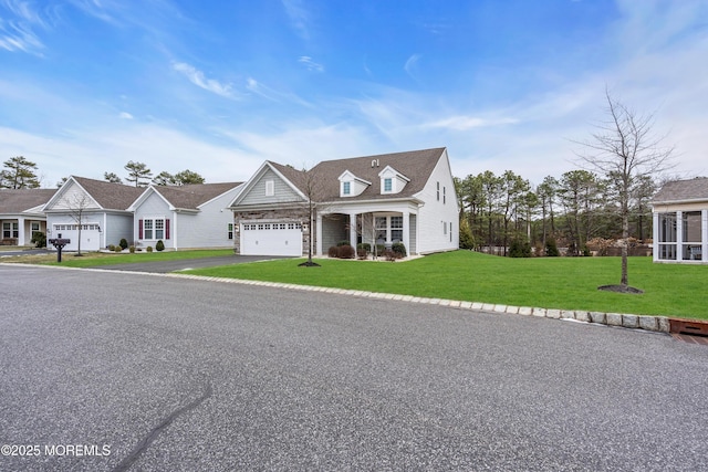 cape cod-style house featuring a front yard and a garage