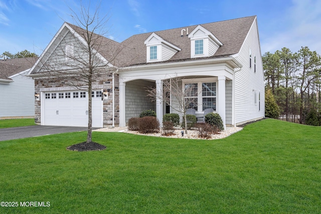 cape cod home featuring a front yard and a garage