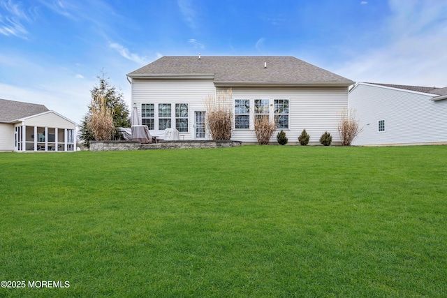 back of house featuring a sunroom and a lawn