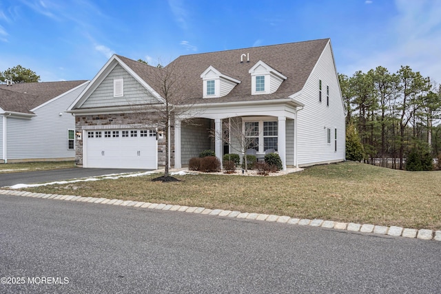 cape cod home with a porch, a front lawn, and a garage