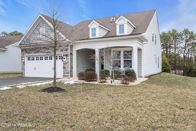 cape cod home with a front yard and a garage