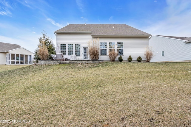 back of house featuring a sunroom and a lawn