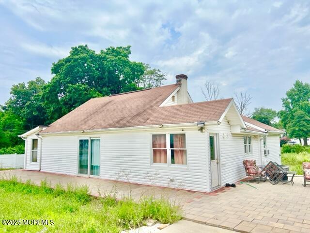 back of property with an outdoor fire pit and a patio