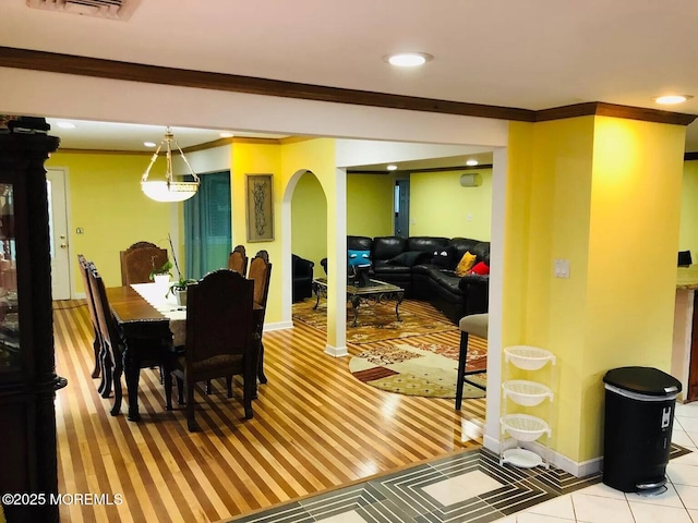 tiled dining space featuring ornamental molding