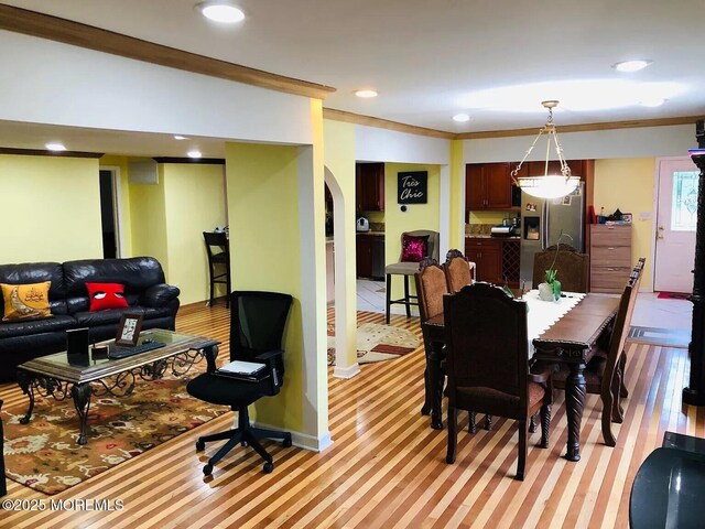 dining room featuring light wood-type flooring and crown molding