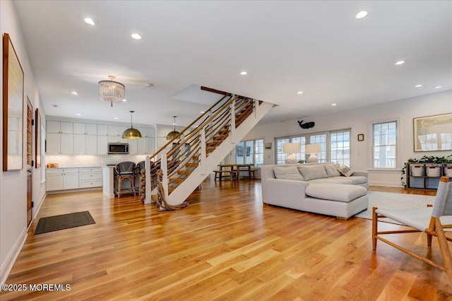 living room with light wood-type flooring and a notable chandelier