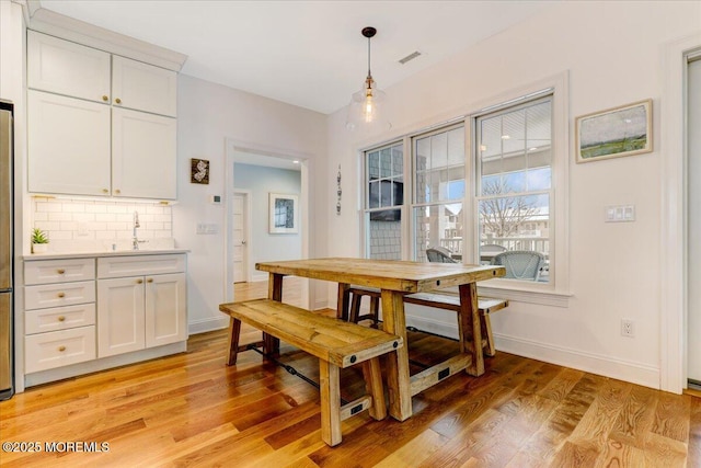 dining space with light hardwood / wood-style flooring and sink