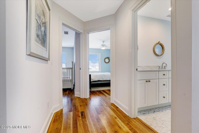 corridor featuring light hardwood / wood-style floors and sink