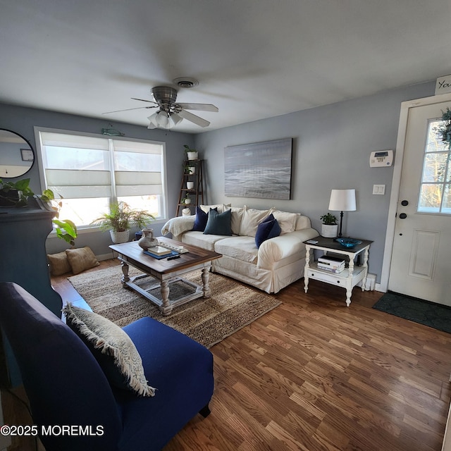 living room featuring ceiling fan and dark hardwood / wood-style floors