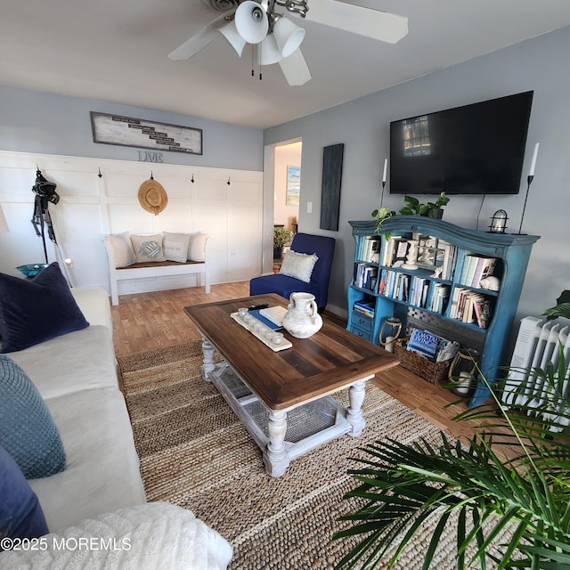 living room featuring ceiling fan and hardwood / wood-style floors