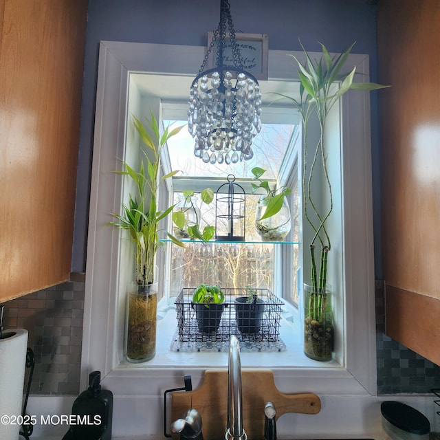 details featuring decorative backsplash and an inviting chandelier