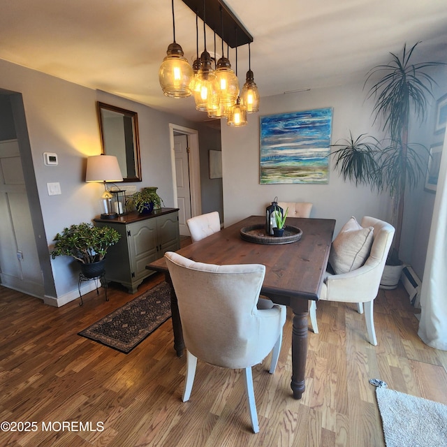 dining space with hardwood / wood-style floors and a chandelier