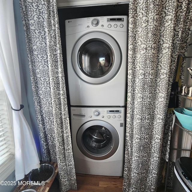 laundry area featuring dark hardwood / wood-style flooring and stacked washer / dryer