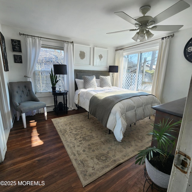 bedroom with ceiling fan, dark wood-type flooring, and multiple windows