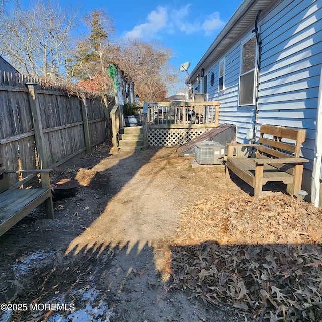 view of yard featuring a wooden deck and central air condition unit