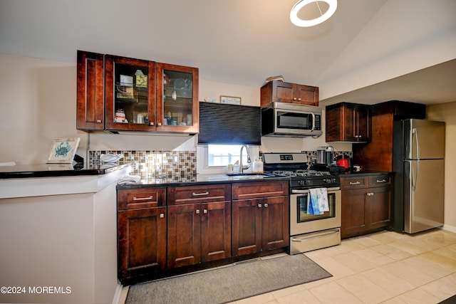 kitchen with stainless steel appliances, tasteful backsplash, light tile patterned flooring, vaulted ceiling, and sink