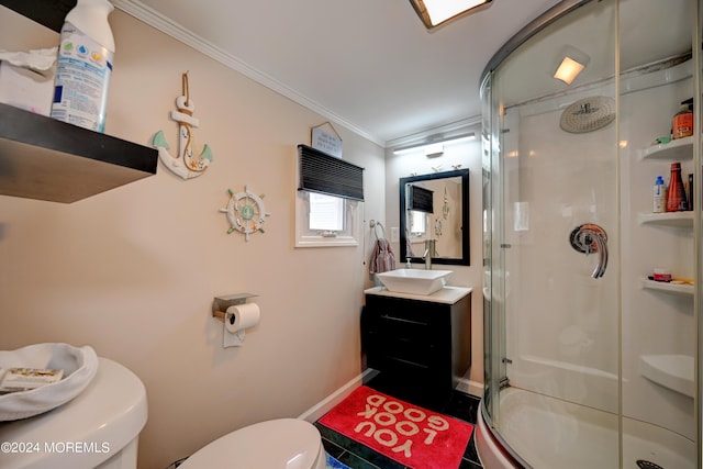 bathroom with a shower with shower door, toilet, vanity, and crown molding