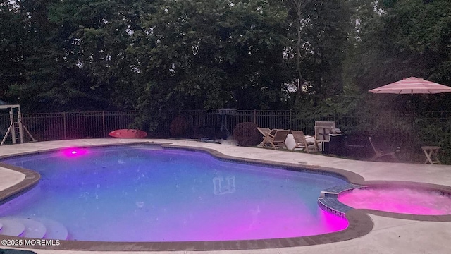 view of pool with a patio area, a pool with connected hot tub, and a fenced backyard