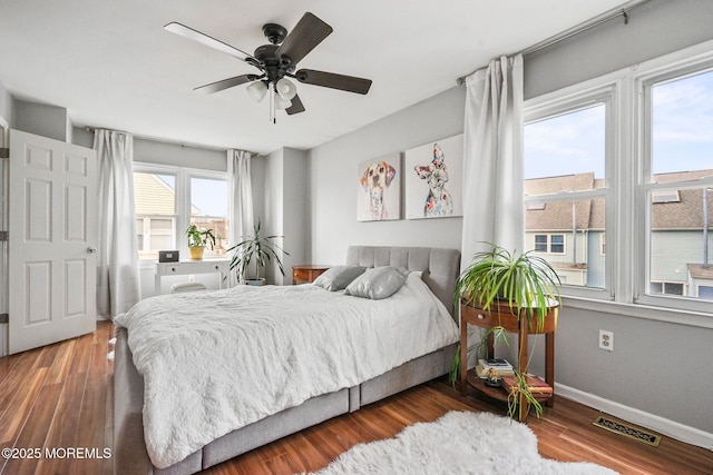 bedroom featuring multiple windows, ceiling fan, and dark wood-type flooring