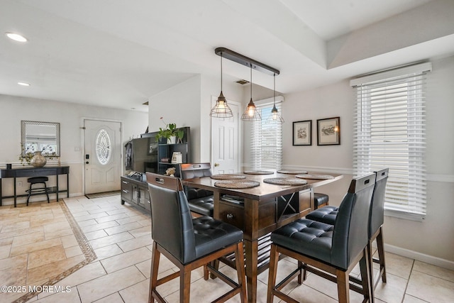 tiled dining space featuring a healthy amount of sunlight