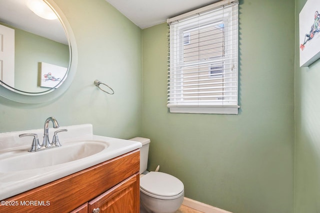 bathroom with toilet, vanity, and plenty of natural light