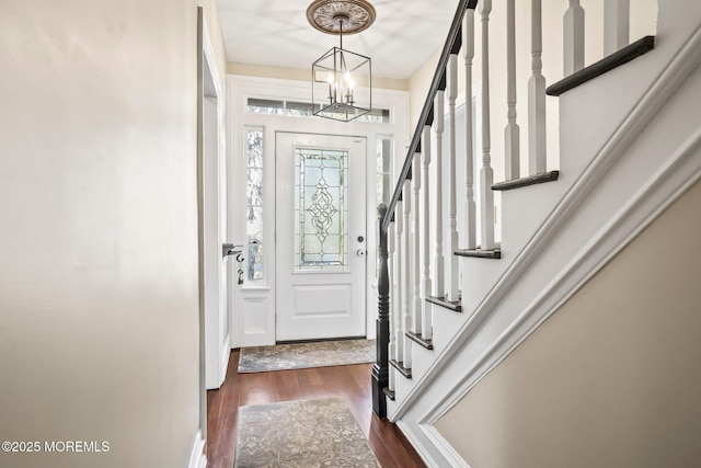 foyer entrance featuring dark wood-type flooring and a notable chandelier