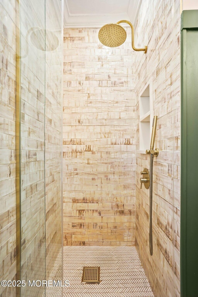 bathroom featuring a shower with shower door and crown molding