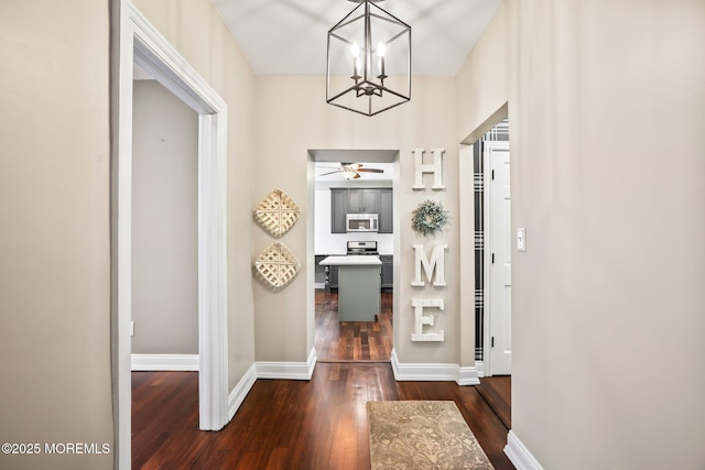 hallway with an inviting chandelier and dark hardwood / wood-style floors