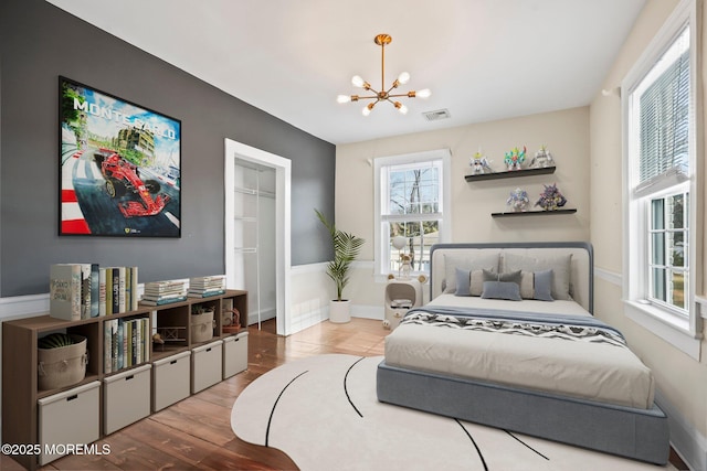 bedroom featuring a notable chandelier and light hardwood / wood-style flooring