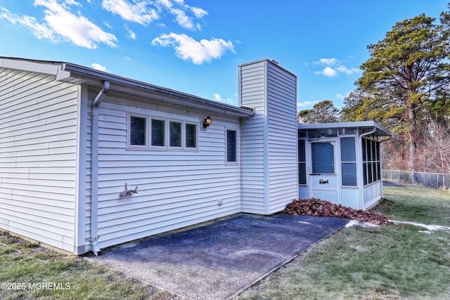 back of property featuring a yard and a sunroom