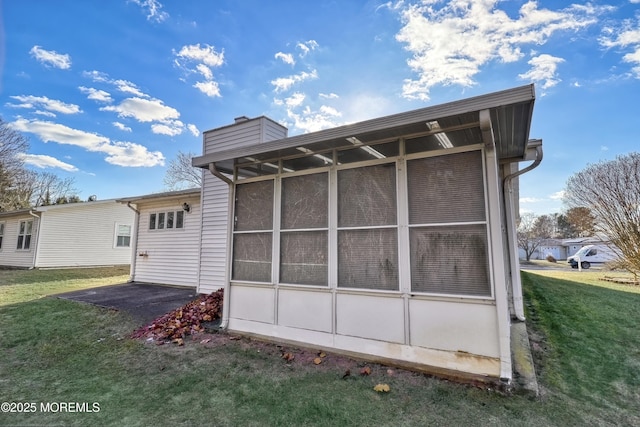 view of side of home with a yard and a sunroom