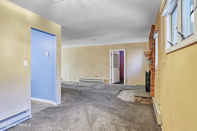 empty room featuring baseboard heating, a brick fireplace, and dark carpet