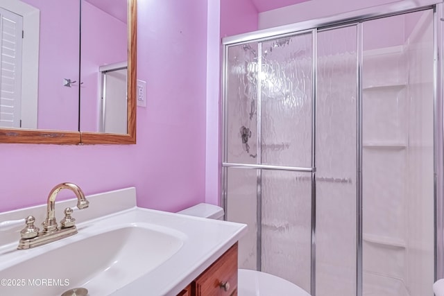 bathroom featuring toilet, an enclosed shower, and vanity