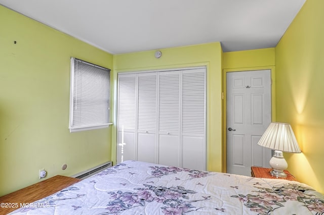 bedroom with baseboard heating and a closet