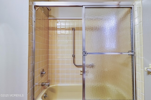 bathroom featuring bath / shower combo with glass door