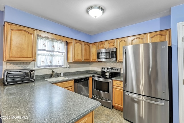 kitchen featuring appliances with stainless steel finishes, light tile patterned floors, tasteful backsplash, and sink