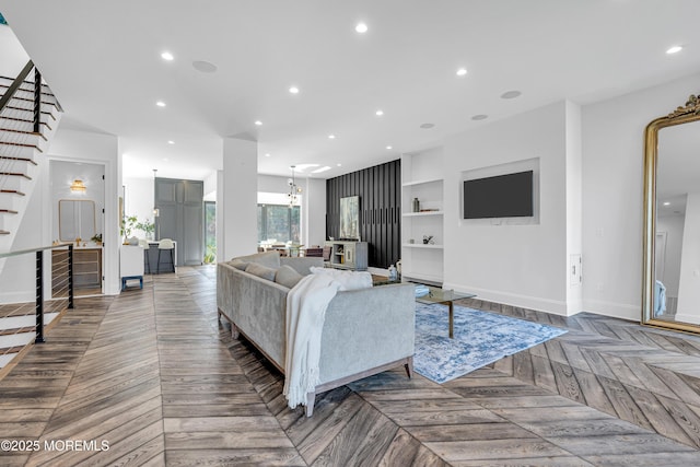 living room with built in shelves and dark parquet flooring