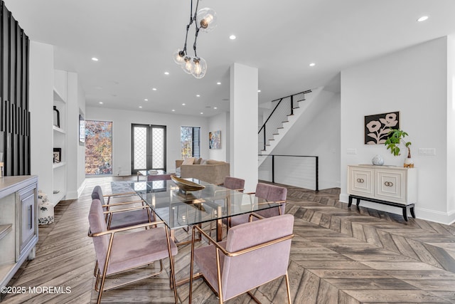 dining space with built in shelves, dark parquet flooring, and french doors