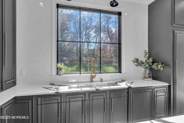 interior space with light stone countertops, plenty of natural light, gray cabinetry, and sink