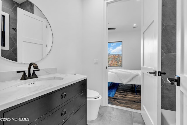 bathroom featuring toilet, vanity, and tile patterned flooring