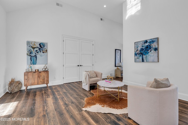 sitting room featuring dark hardwood / wood-style flooring and a towering ceiling