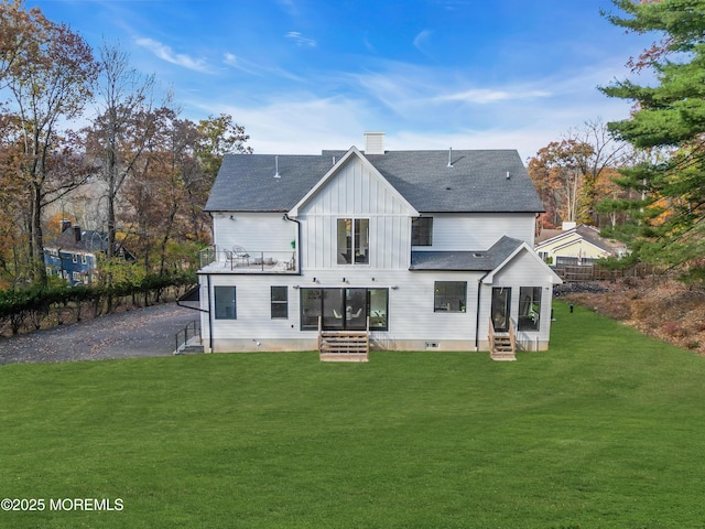 back of property with a balcony and a yard